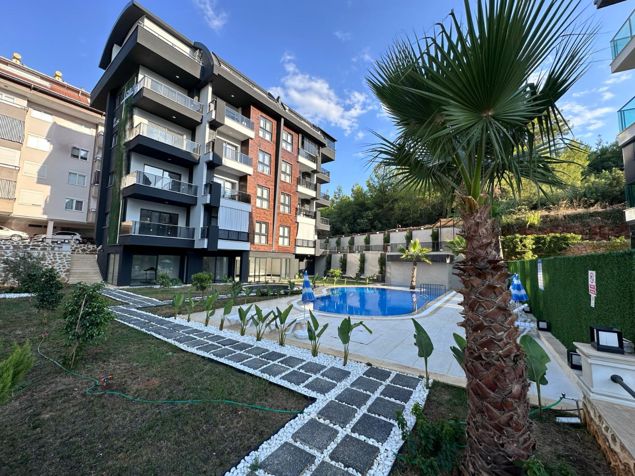 Panoramik balkonlu rezidans bloğu, Türkiye’de satılık dairelerin bulunduğu sitede açık havuzun yanında