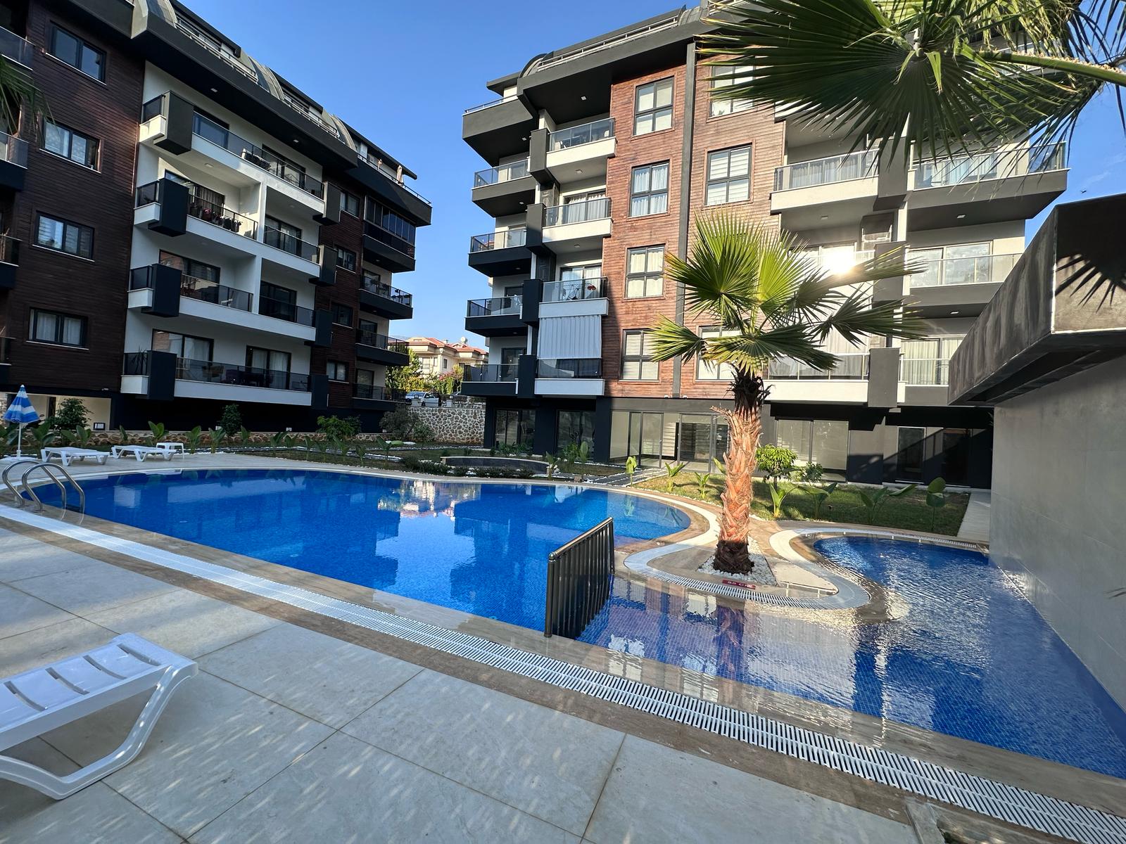 Palmalı yuvarlak su alanı, açık havuzun yanında Oba’daki satılık dairelerin bulunduğu komplekste