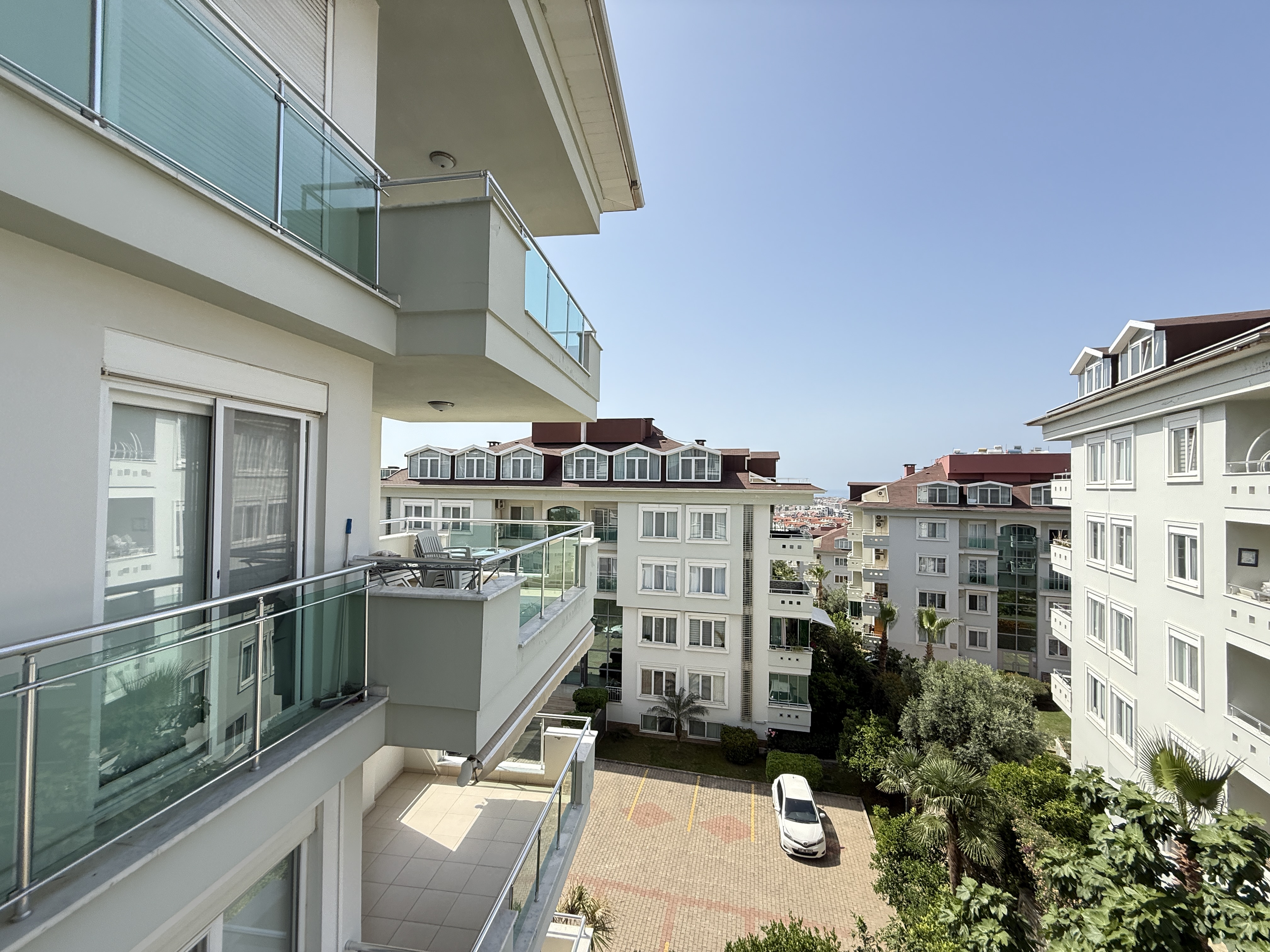 Cam korkuluklu balkon ve şehir yapılarına bakan manzara, satılık rezidansta