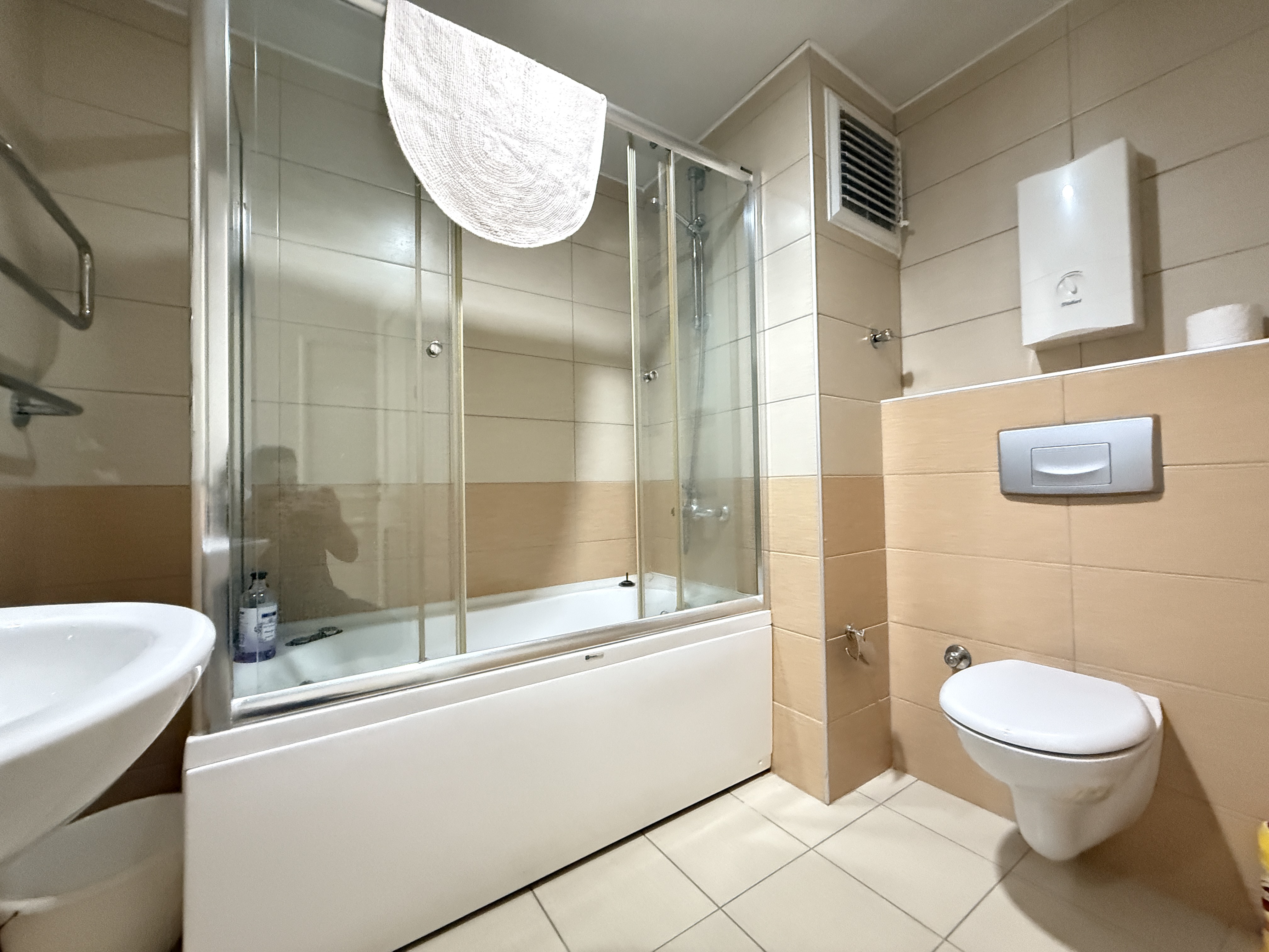 Cam bölmeli küvet ve asma klozet bulunan banyo