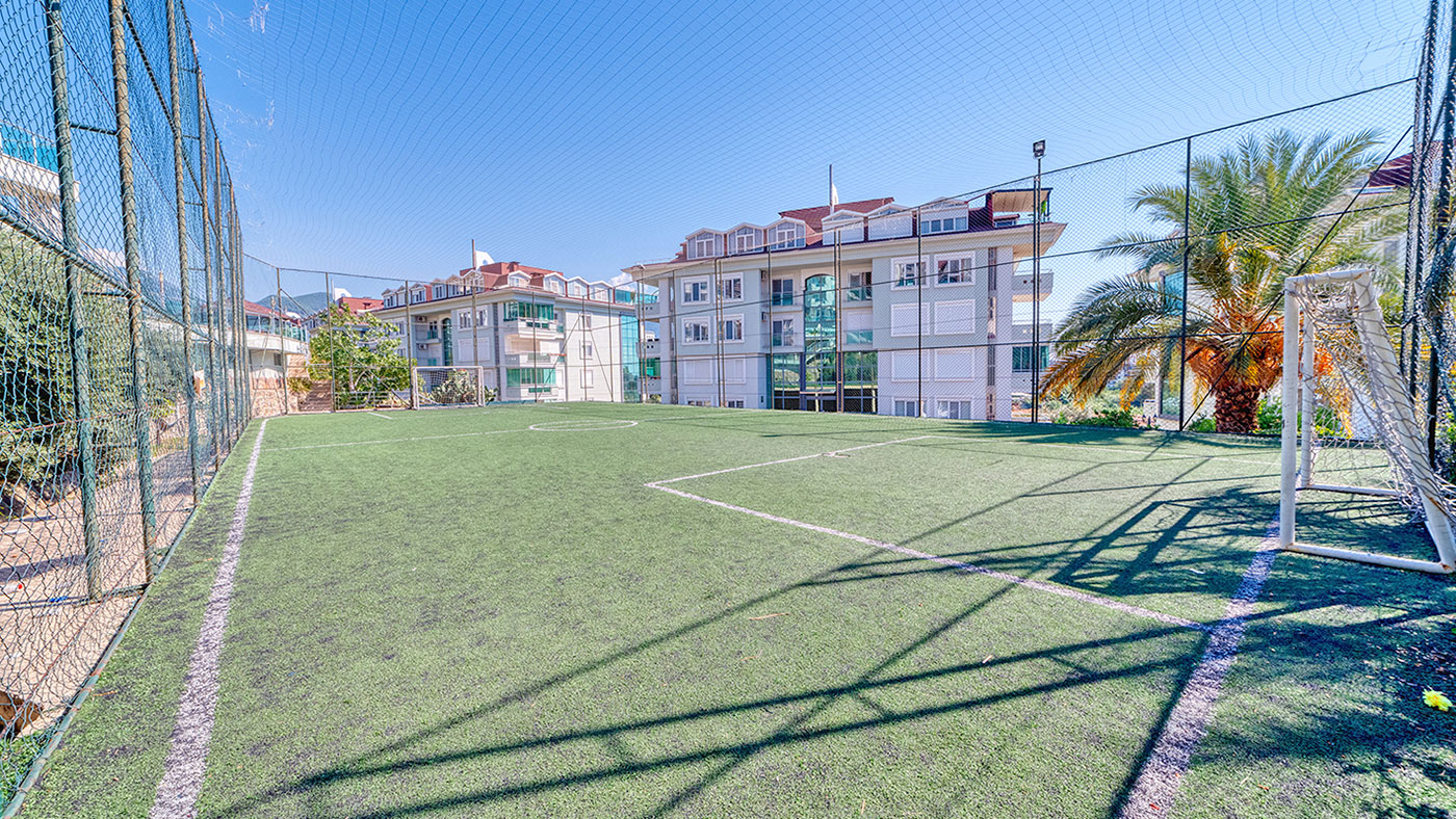 Yapay çimli futbol sahası ve yüksek koruma ağı, Oba’daki site alanında