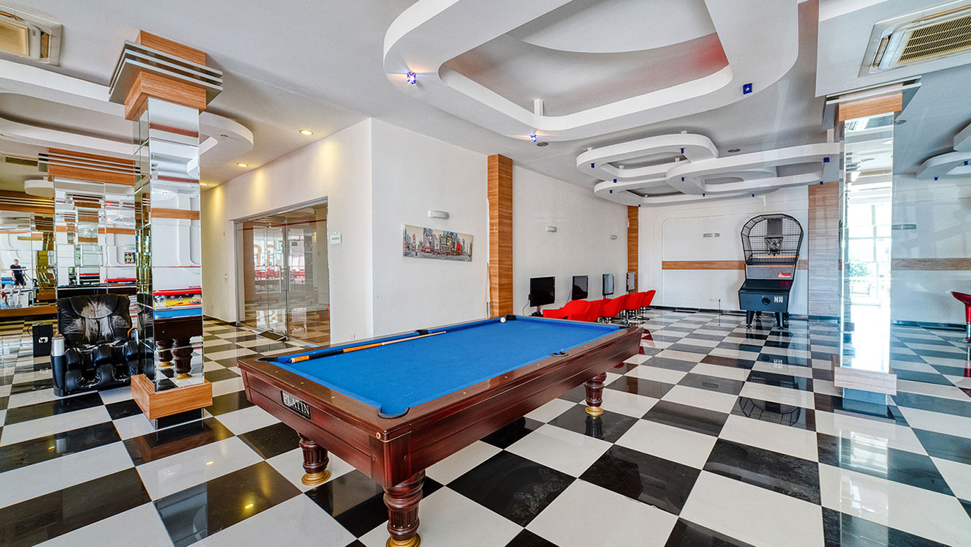 Mavi çuhalı bilardo masası ve siyah beyaz zemin, Oba’daki rekreasyon alanında