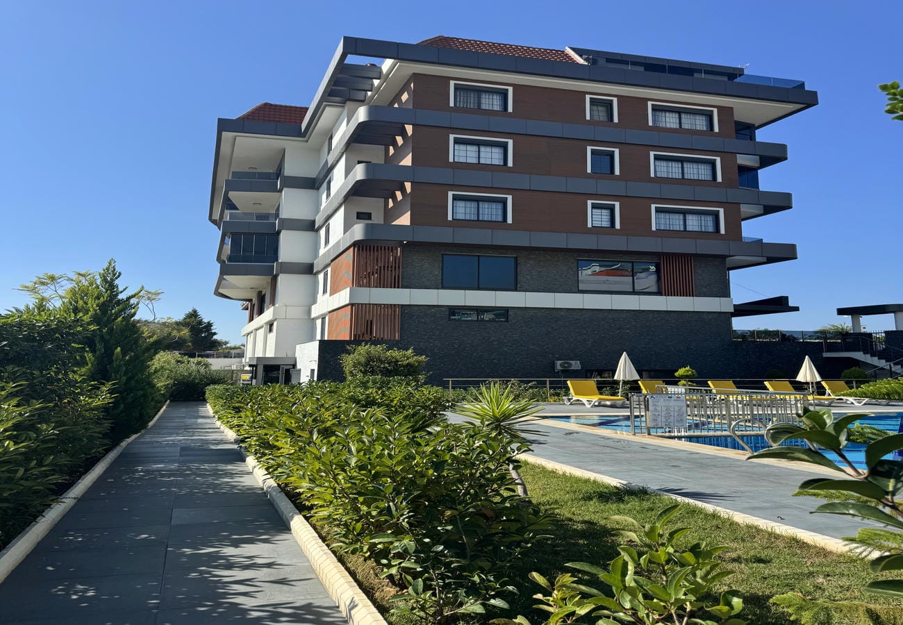 Panoramik pencereli konut bloğu dairelerin bulunduğu açık havuzlu alana bakıyor