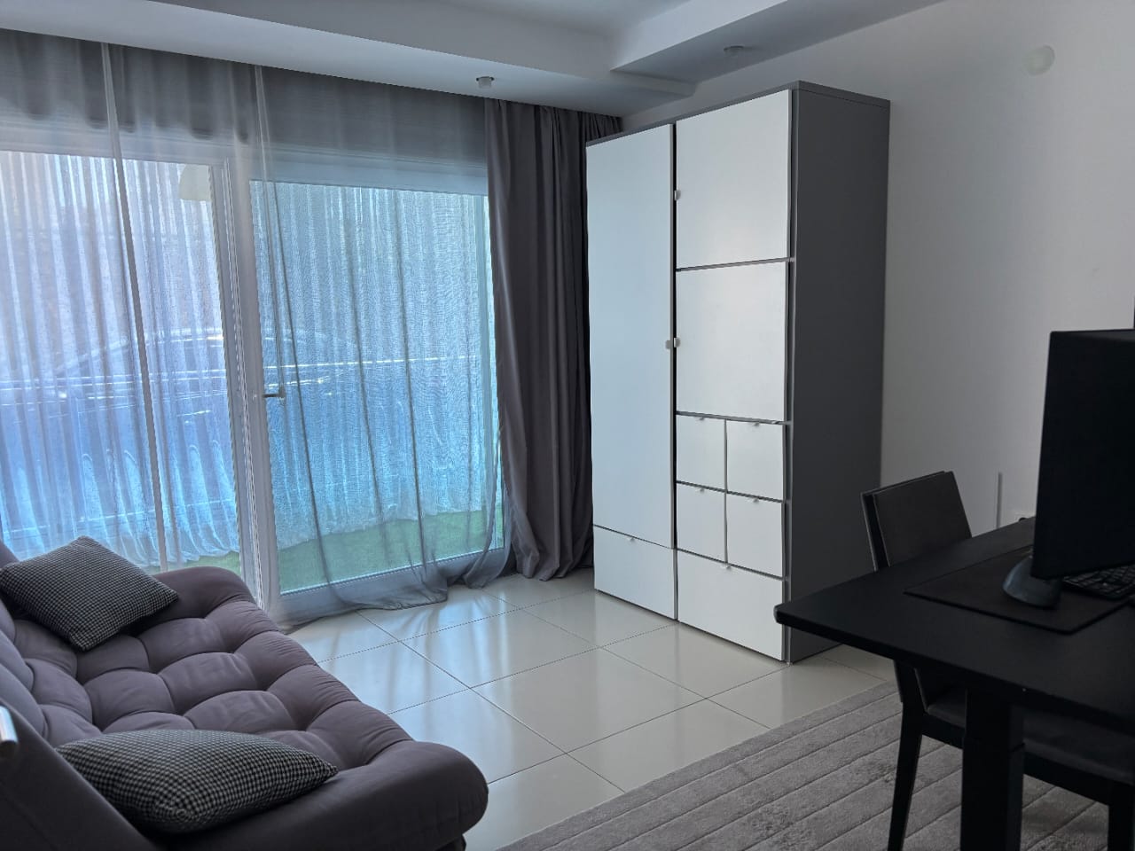 Gri kanepeli yatak odasında çalışma masası ve panoramik pencere, Kestel’de