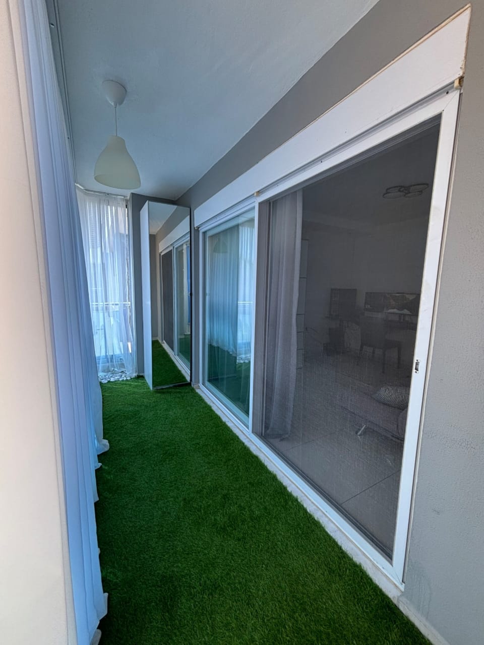 Yeşil zeminli camla kapalı balkon, Türkiye’de satılık dairede sürgülü cam kapılarla
