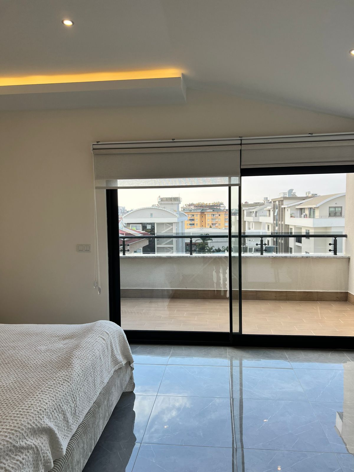 Teras kapısına açılan sürgülü camlı yatak odası, penthouse’un şehir manzarasına bakıyor