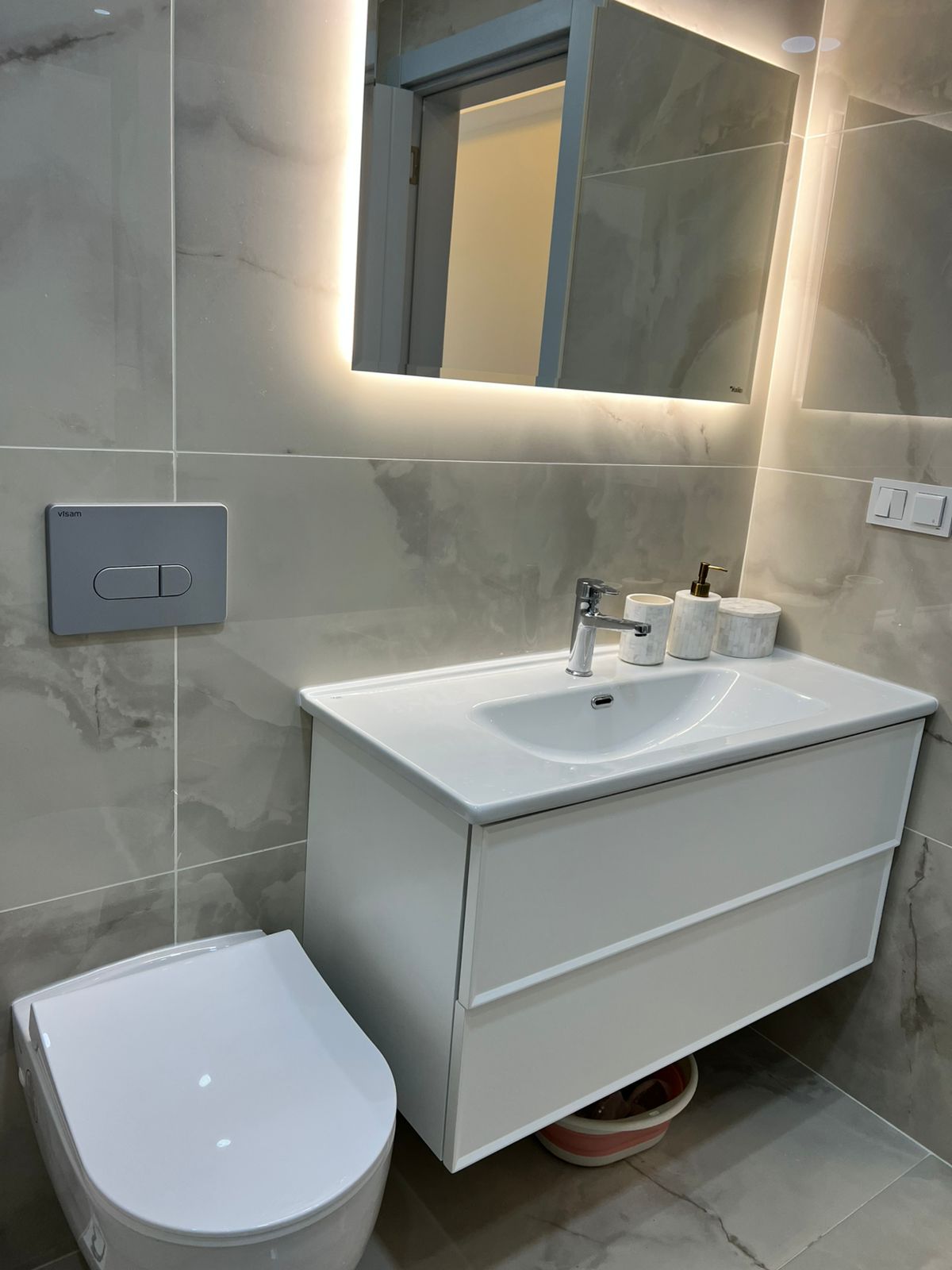 Lavabo, asma klozet ve ışıklı aynalı banyo penthouse’un mermer duvarlarıyla görülüyor