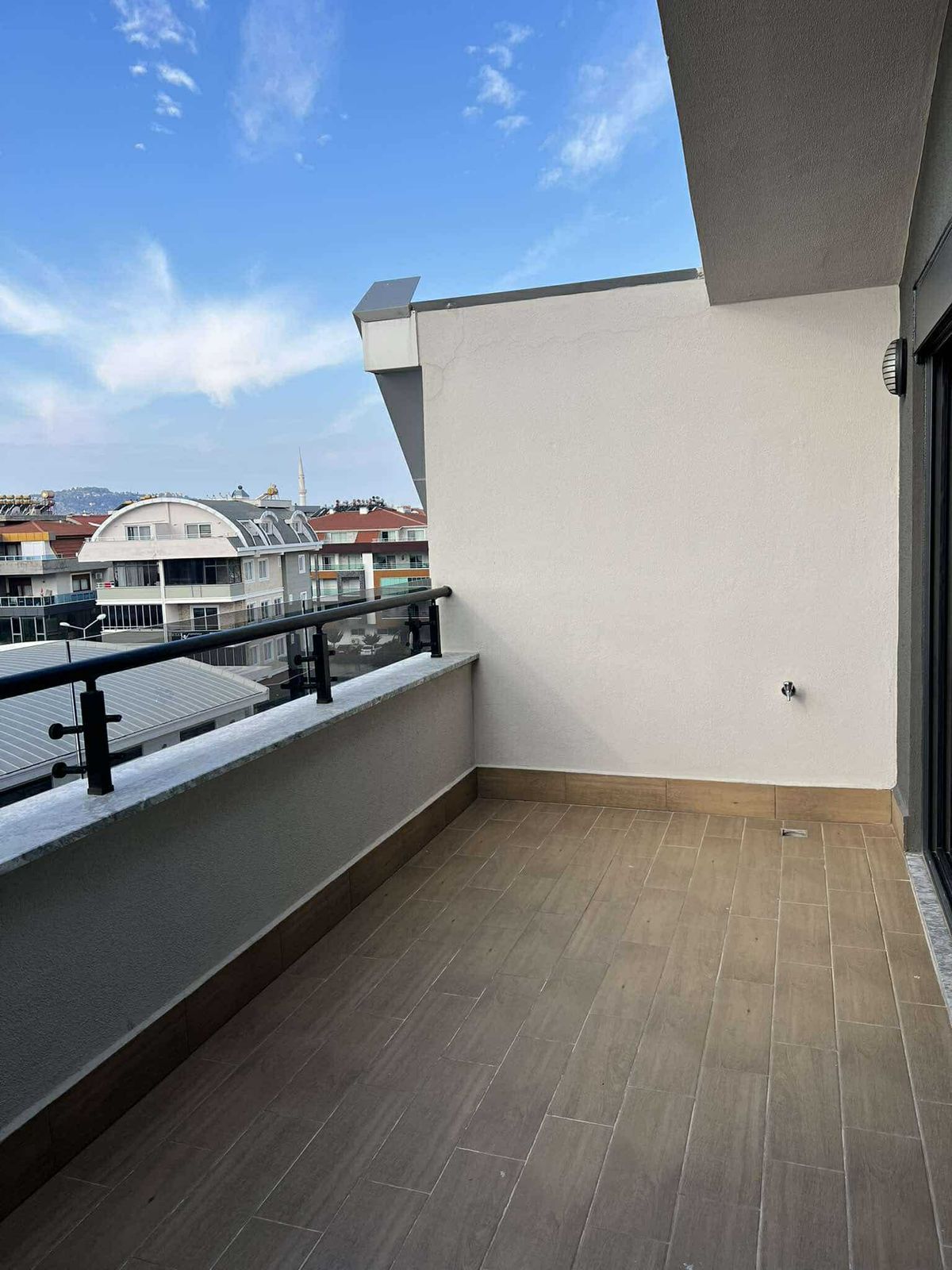 Cam korkuluklu geniş teras ve sürgülü cam kapı Türkiye’deki penthouse’un dışında bulunuyor