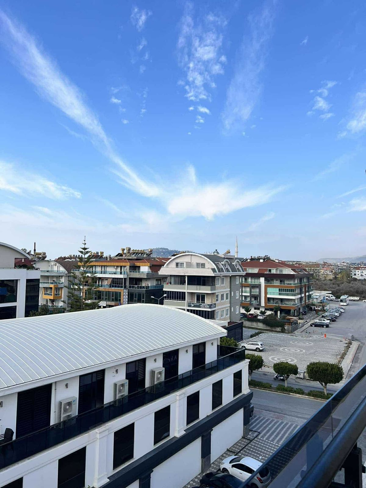 Dağ sırtına uzanan konut mahallesi manzarasında açık renkli metal çatı görülüyor
