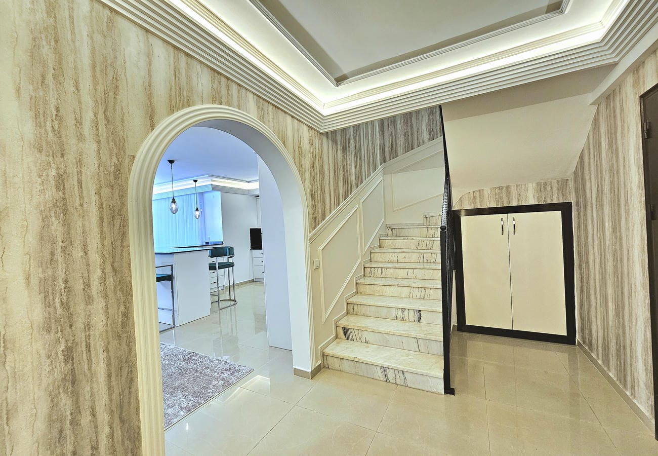 Mermer basamaklı hol penthouse dairesinde kemerli geçiş ve gömme dolapla
