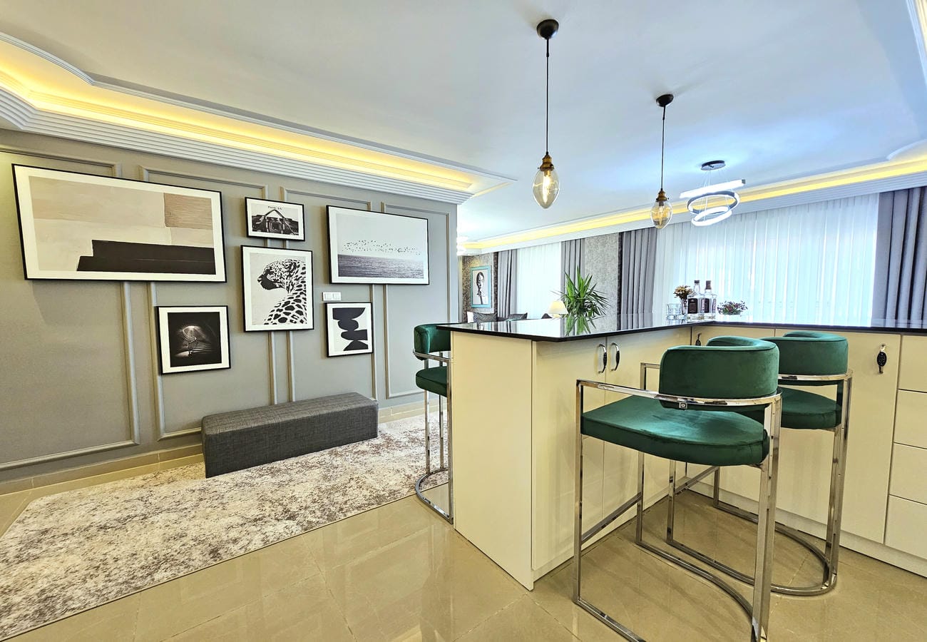 Adalı mutfaklı salon Oba’daki rezidans dairesinde panoramik camlarla