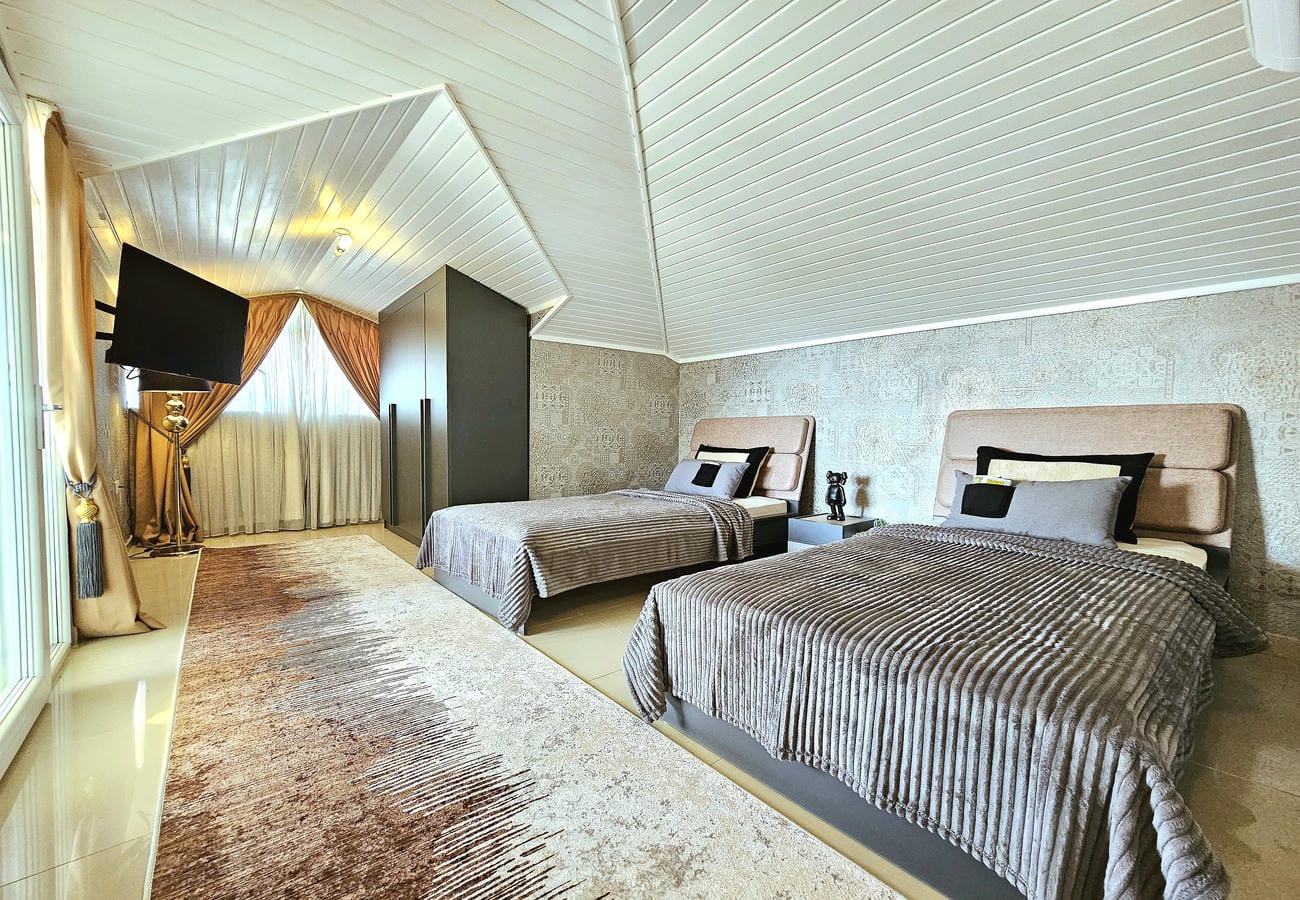 İki tek kişilik yataklı yatak odası penthouse dairesinde eğimli beyaz tavanla