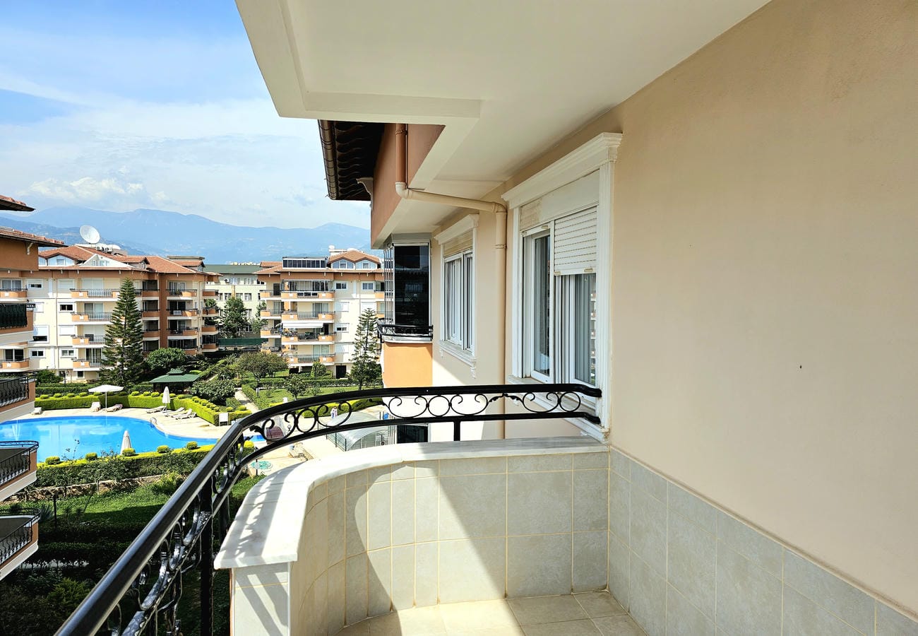 Köşe balkon penthouse dairede avlu havuzu ve uzaktaki dağ sırtıyla satılık