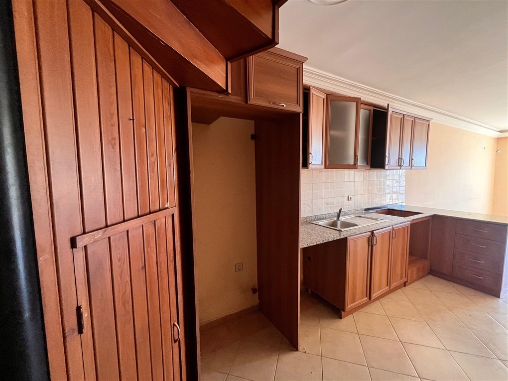 Doğrusal ahşap mutfak ve granit tezgâh Oba’daki penthouse içinde