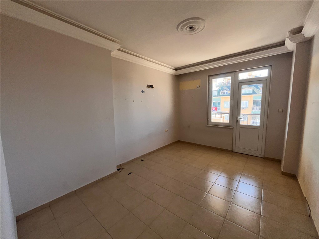 Balkon kapılı boş oda ve karşı bina cephesi üst kattaki rezidansta