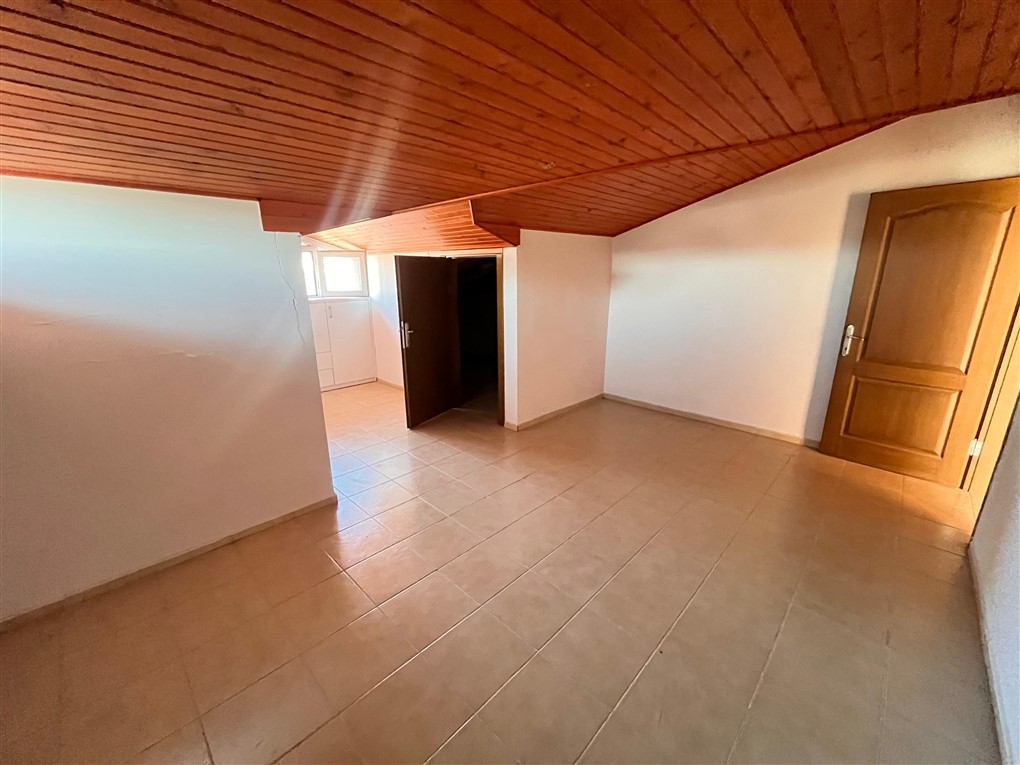 Ahşap çıtalı tavanı ve yan bölüme geçişi olan boş oda Oba’daki penthouse içinde