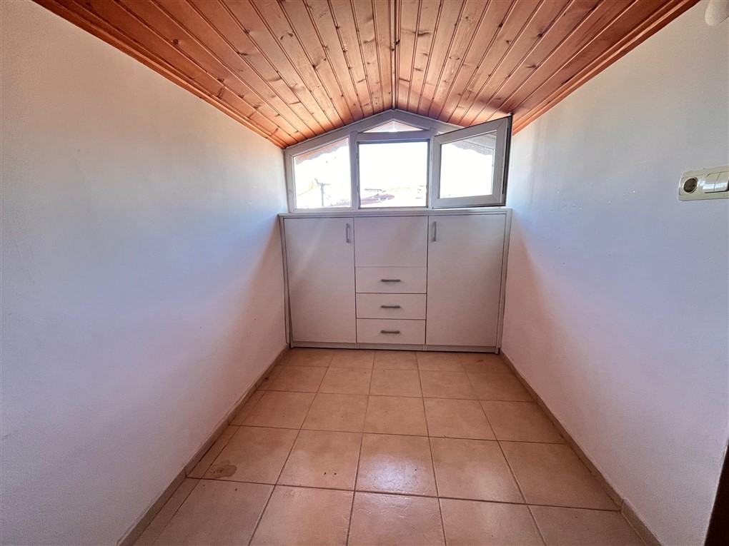 Gömme dolaplı dar oda ve küçük pencere penthouse içinde