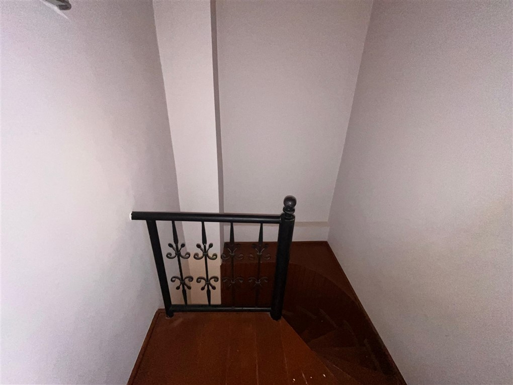 Kıvrımlı demir korkuluklu ahşap merdiven iç mekânda