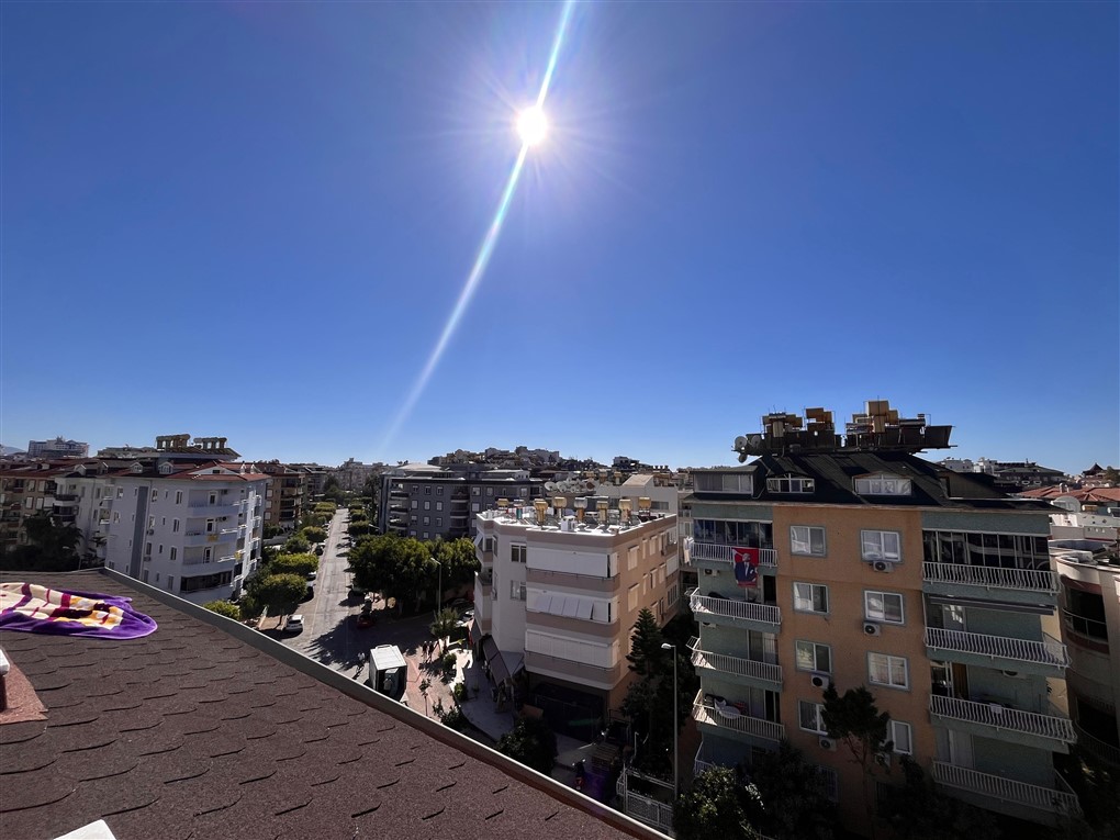 Ağaçlı cadde ve balkonlu binalarla Oba’nın şehir manzarası