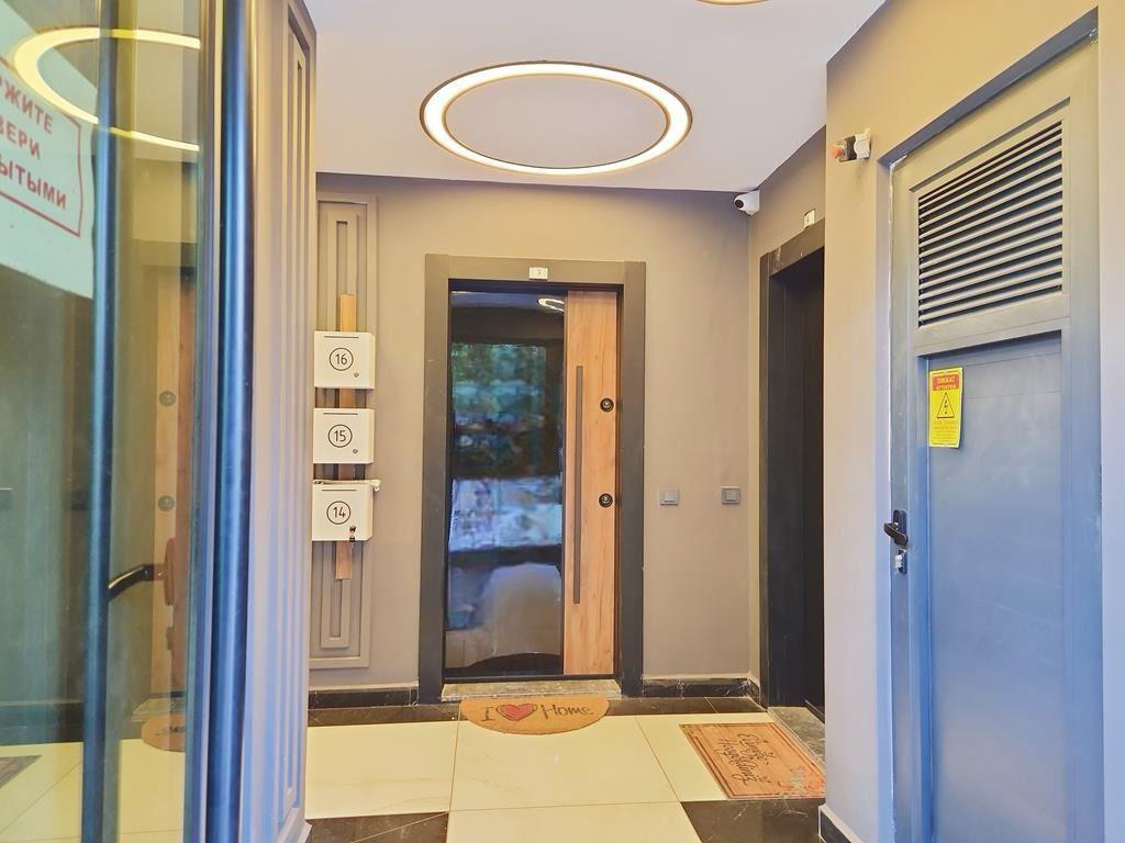 Entry hall with light floor tiles and an entrance door in a penthouse in Oba