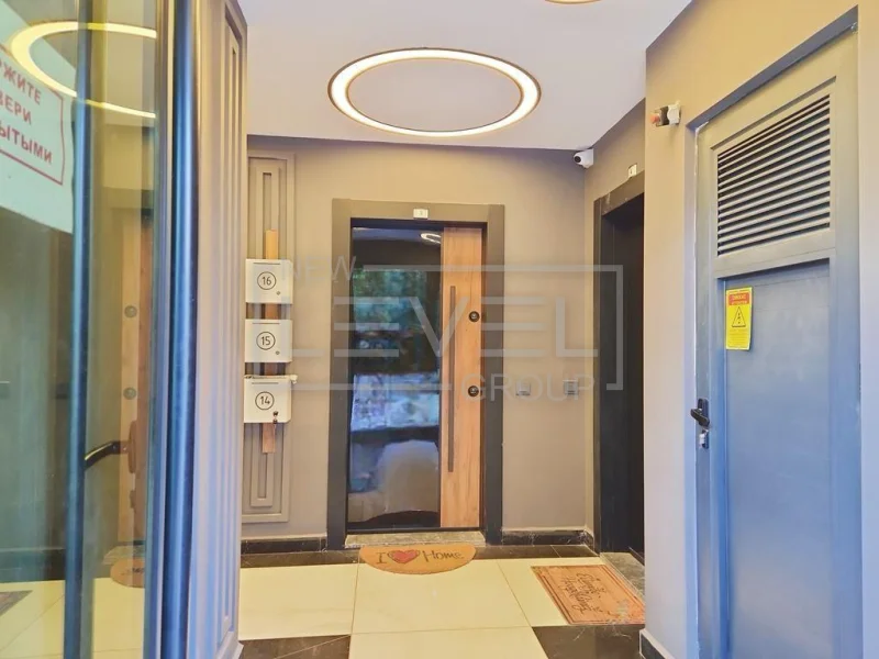 Entry hall with light floor tiles and an entrance door in a penthouse in Oba