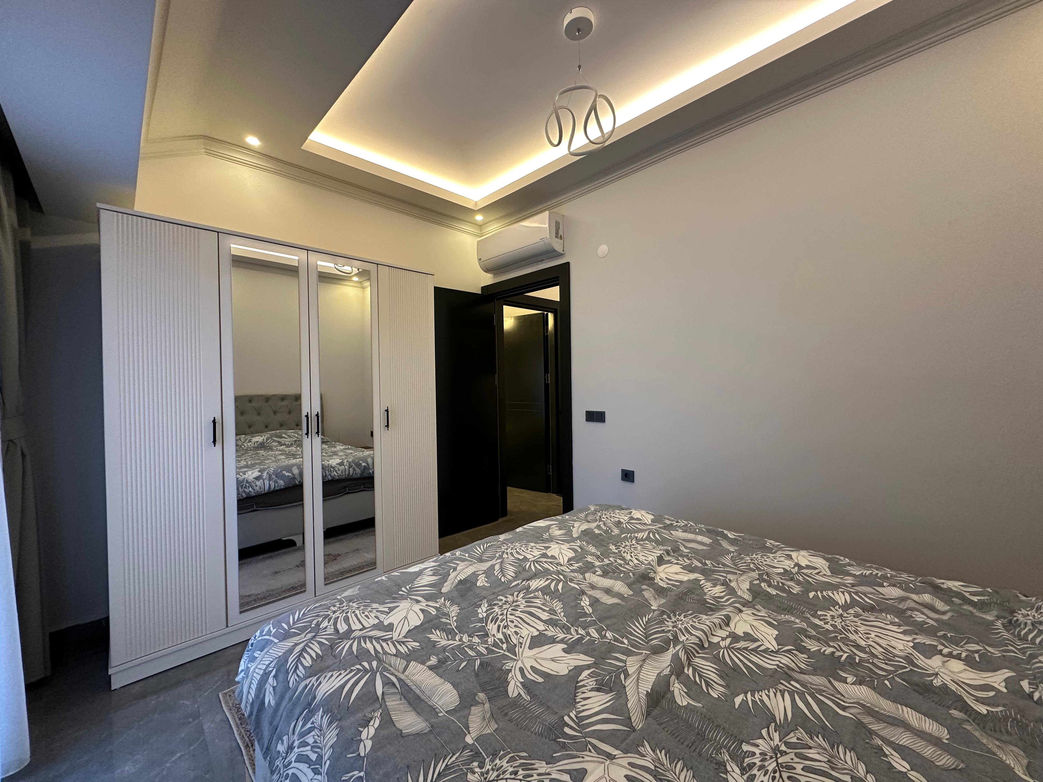 Another bedroom with a double bed, mirrored wardrobe and air conditioner in a duplex