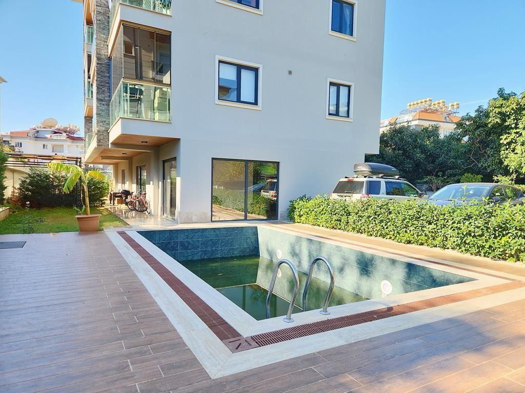 Small outdoor pool with blue lining and a stainless steel ladder in a complex with penthouses for sale in Turkey