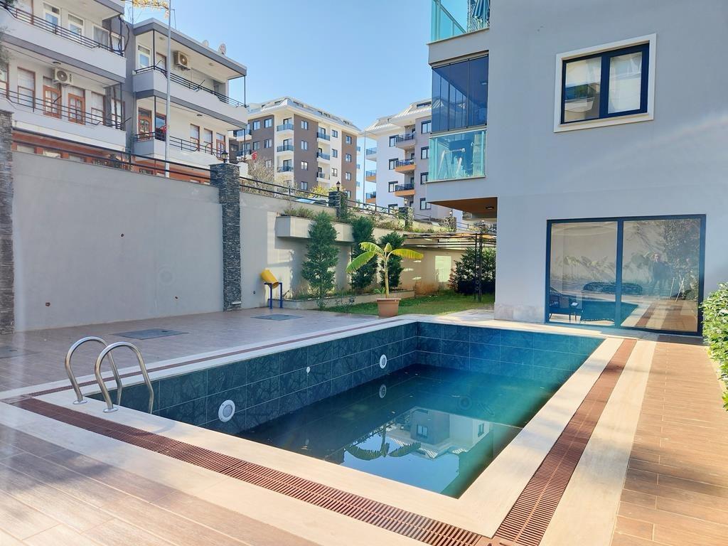 Rectangular outdoor pool with mosaic lining and glass balconies in Oba, Alanya, Turkey