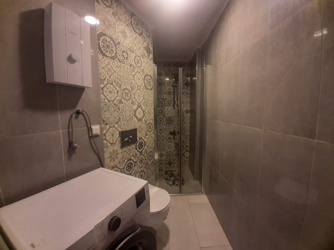 Çamaşır makineli ve cam kapılı duş kabinli banyo, konutta
