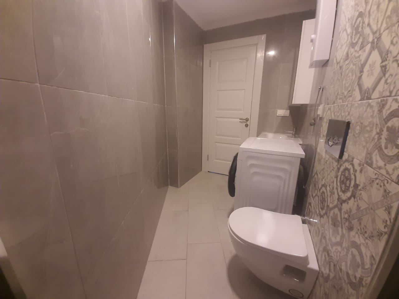 Asma beyaz lavabolu ve desenli fayanslı banyo, dairede