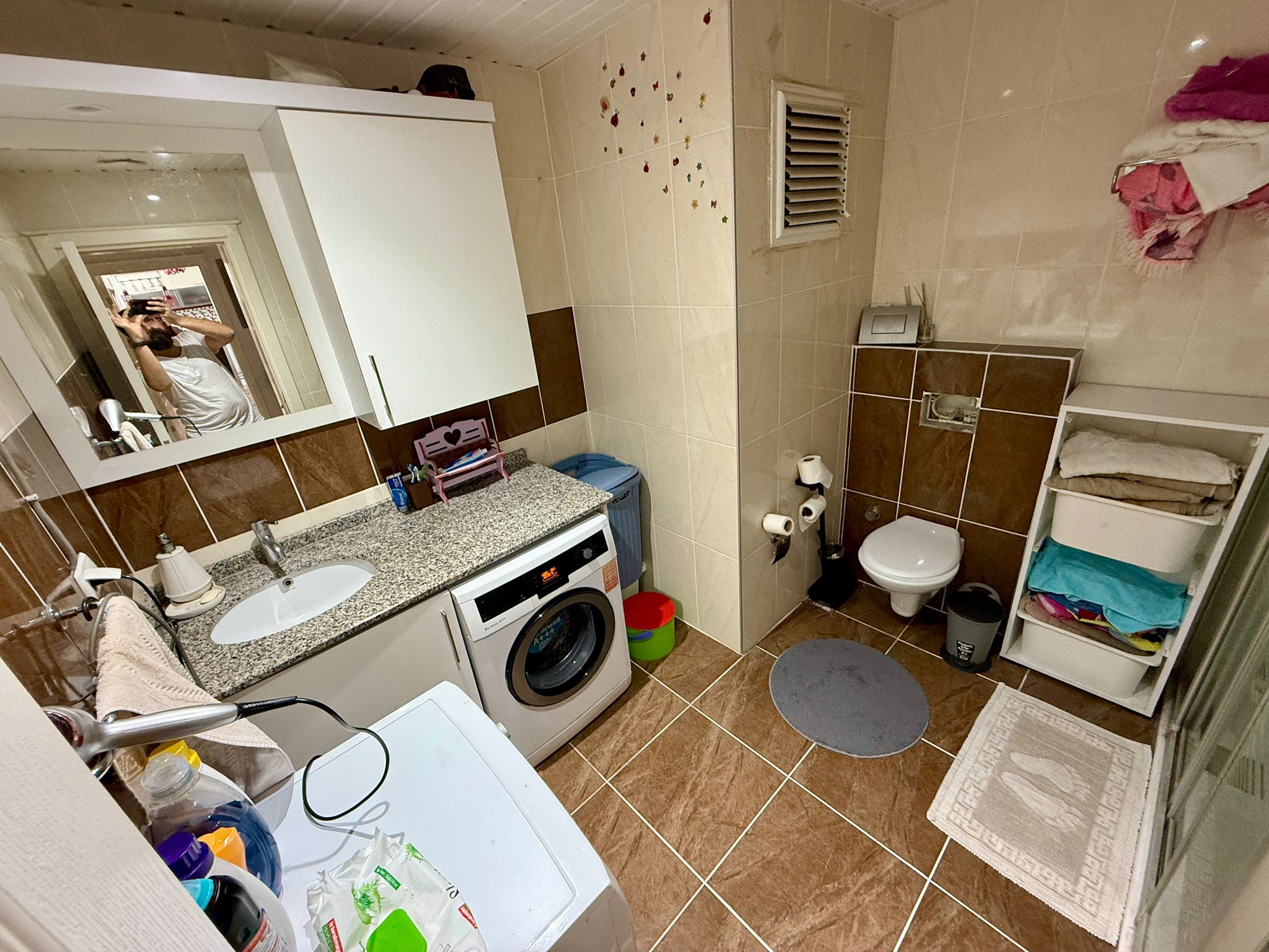 Alanya’daki 2+1 dairenin banyosunda buzlu cam duş kabini ve granit tezgâha gömülü lavabo