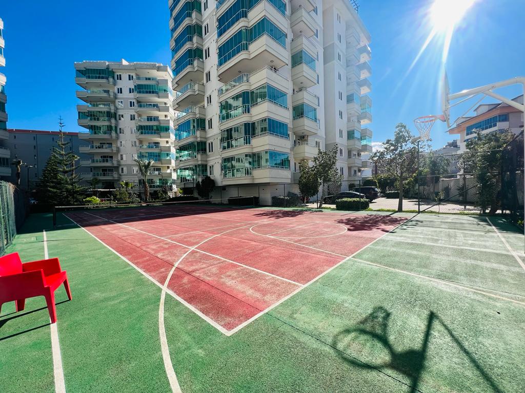 Konut sakinleri için beyaz çizgili, potalı ve kırmızı-yeşil zeminli basketbol sahası