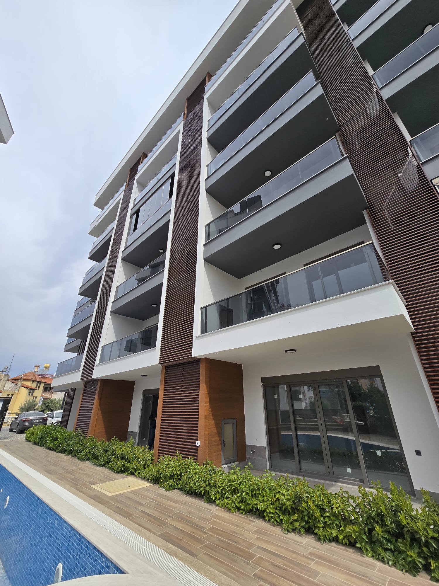 Cam balkonlu çok katlı cephe ve havuz kenarıyla Tosmur’da satılık 2+1 daire, Alanya, Türkiye — New Level Group