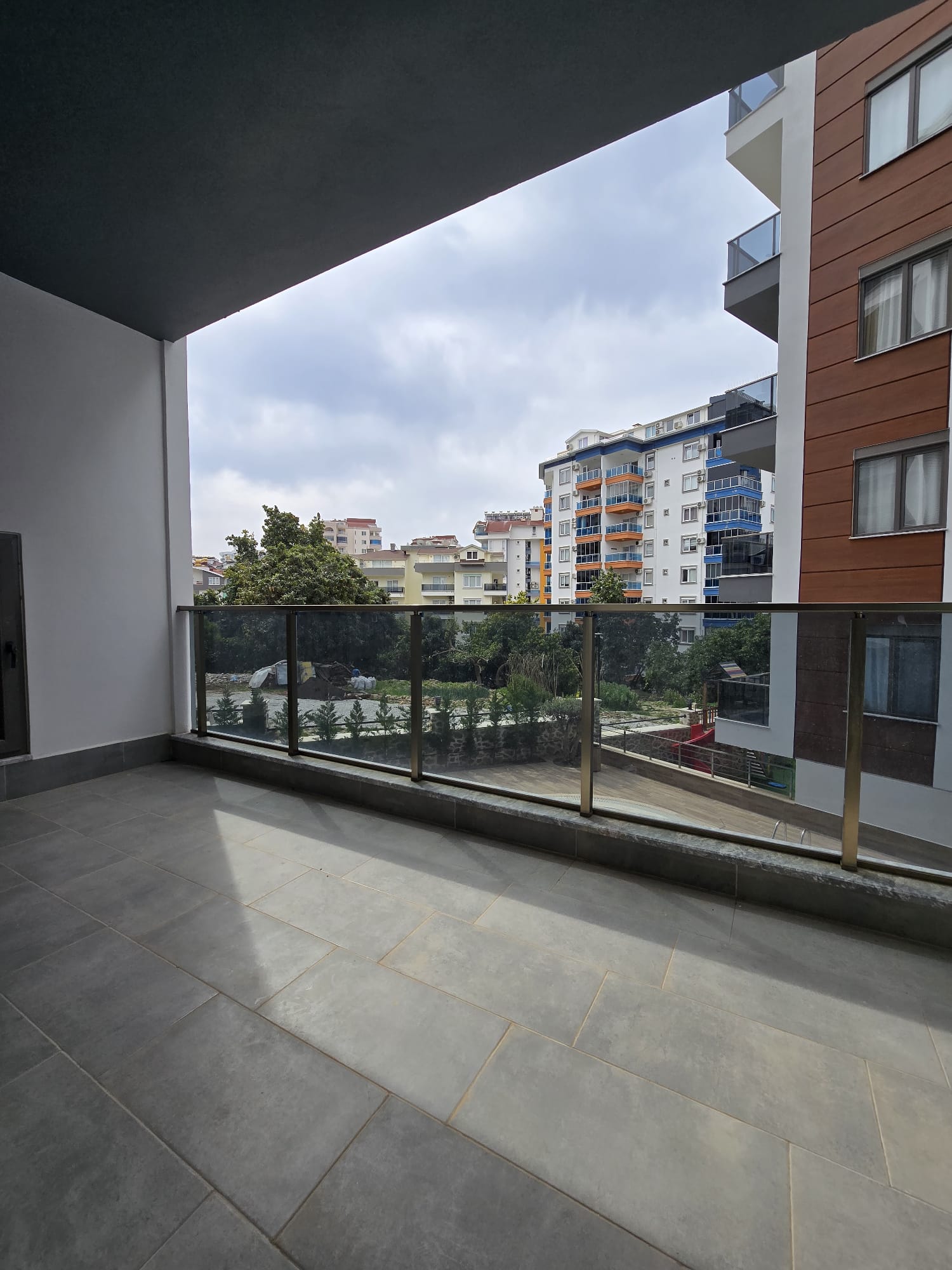 Cam korkuluklu geniş kapalı teras ve konut manzarası satılık dairede
