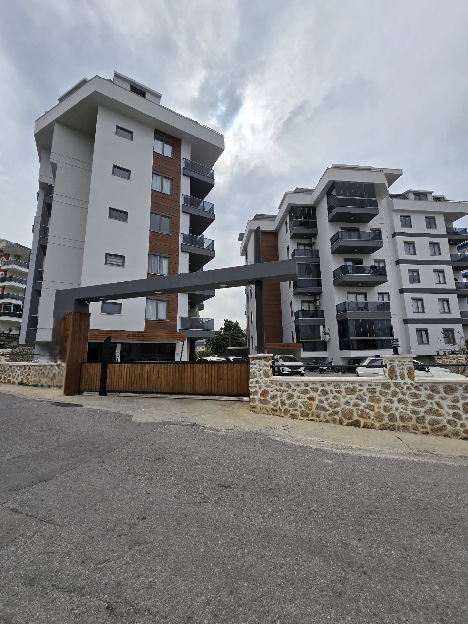Beyaz cepheli ve koyu cam balkonlu birkaç blok Türkiye’de satılık konutların bulunduğu sitede