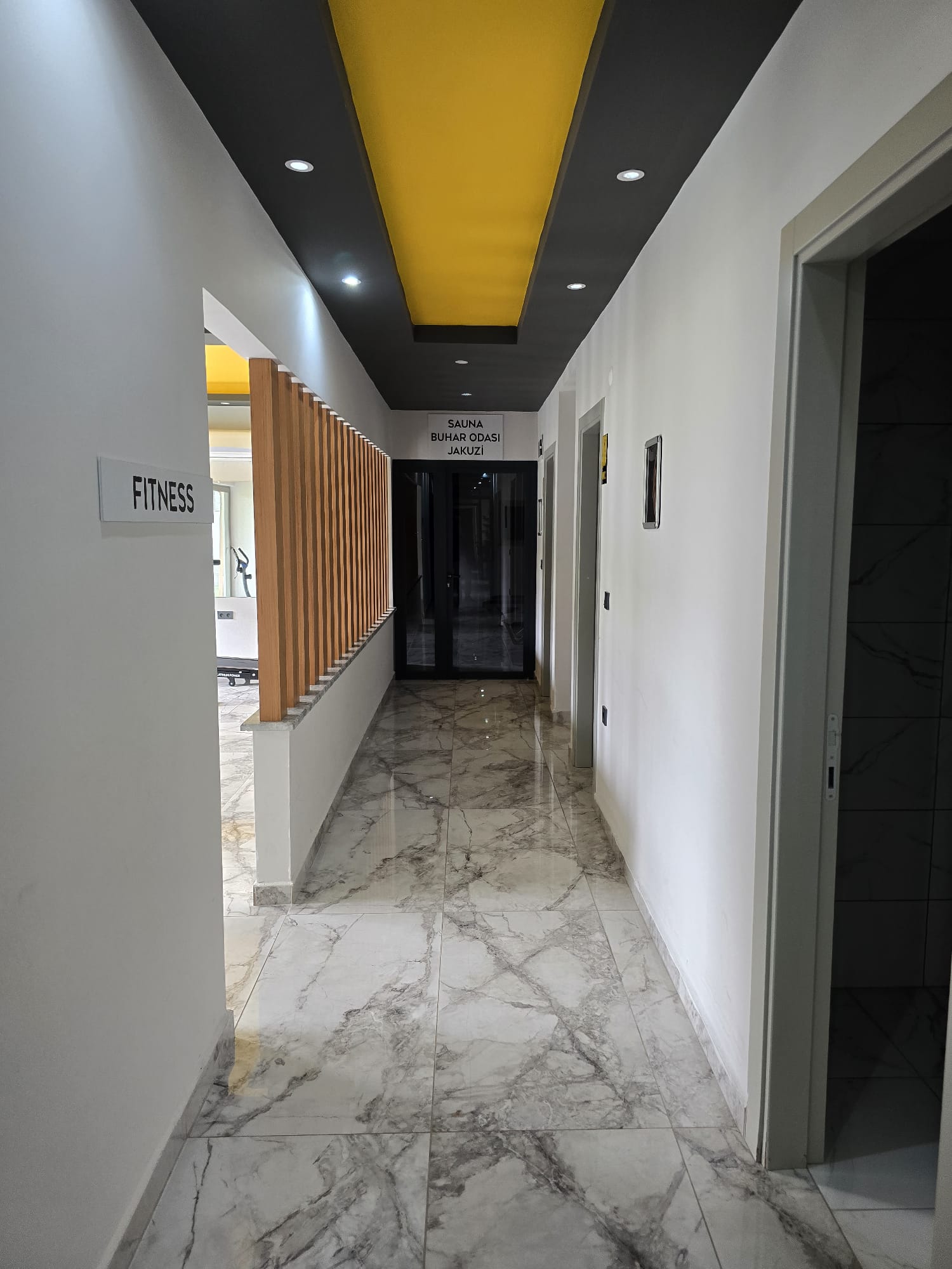 Mermer zeminli spa bölümü, odalara açılan kapılar ve ahşap bölme