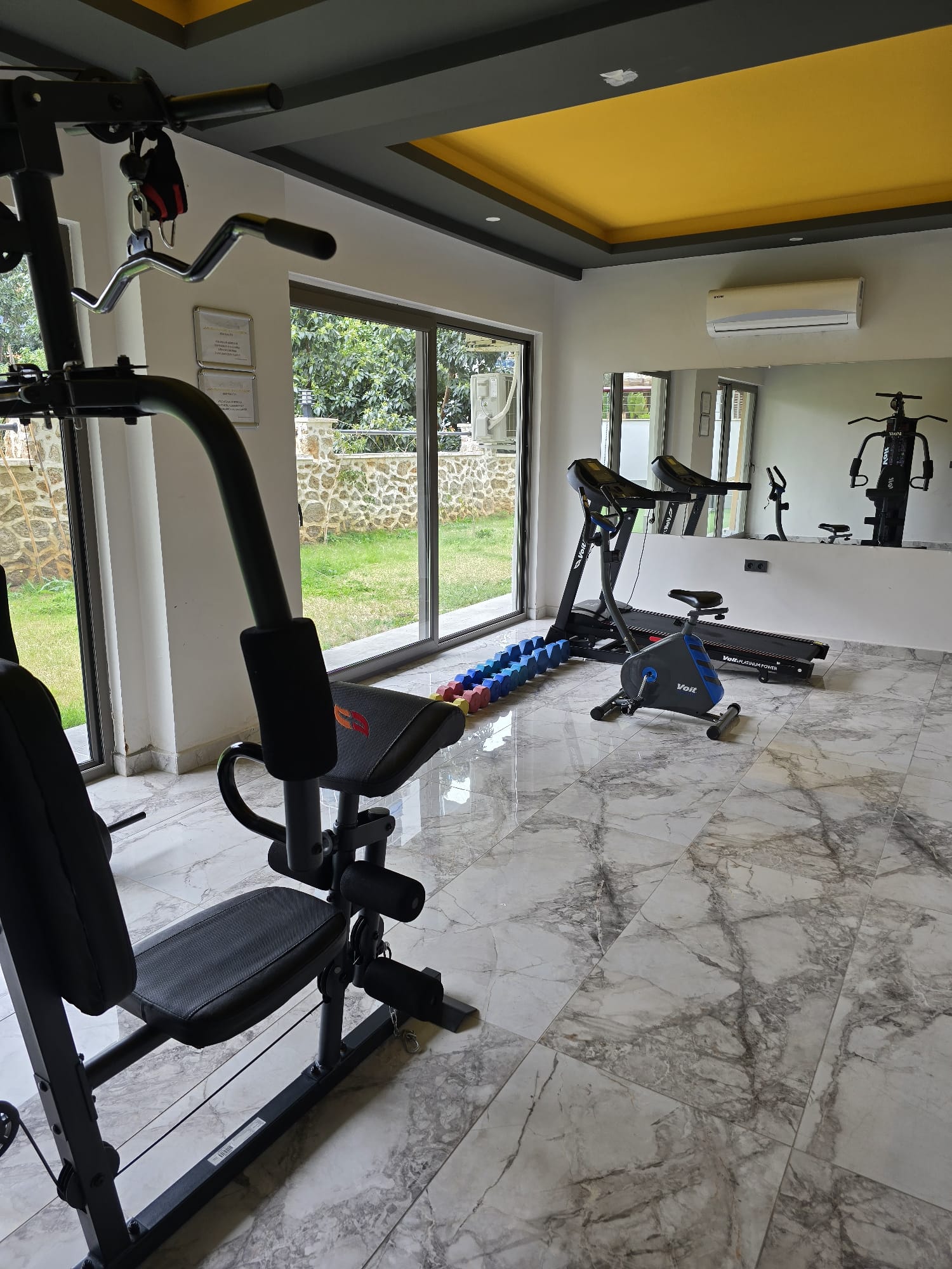 Çok işlevli alet, kondisyon bisikleti ve dambıllarla dairelerin bulunduğu kompleksteki fitness salonu