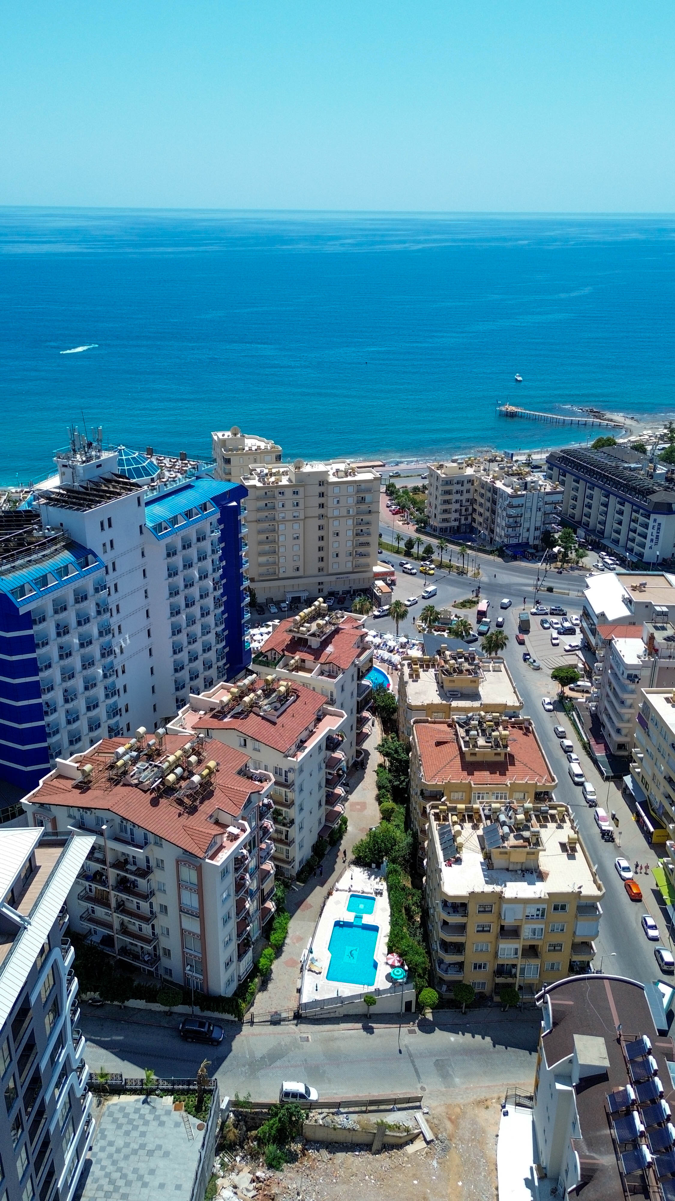 Açık deniz panoraması ve avlu havuzu Türkiye’de Tosmur’daki dairelerin bulunduğu sitede çok katlı binalarla birlikte