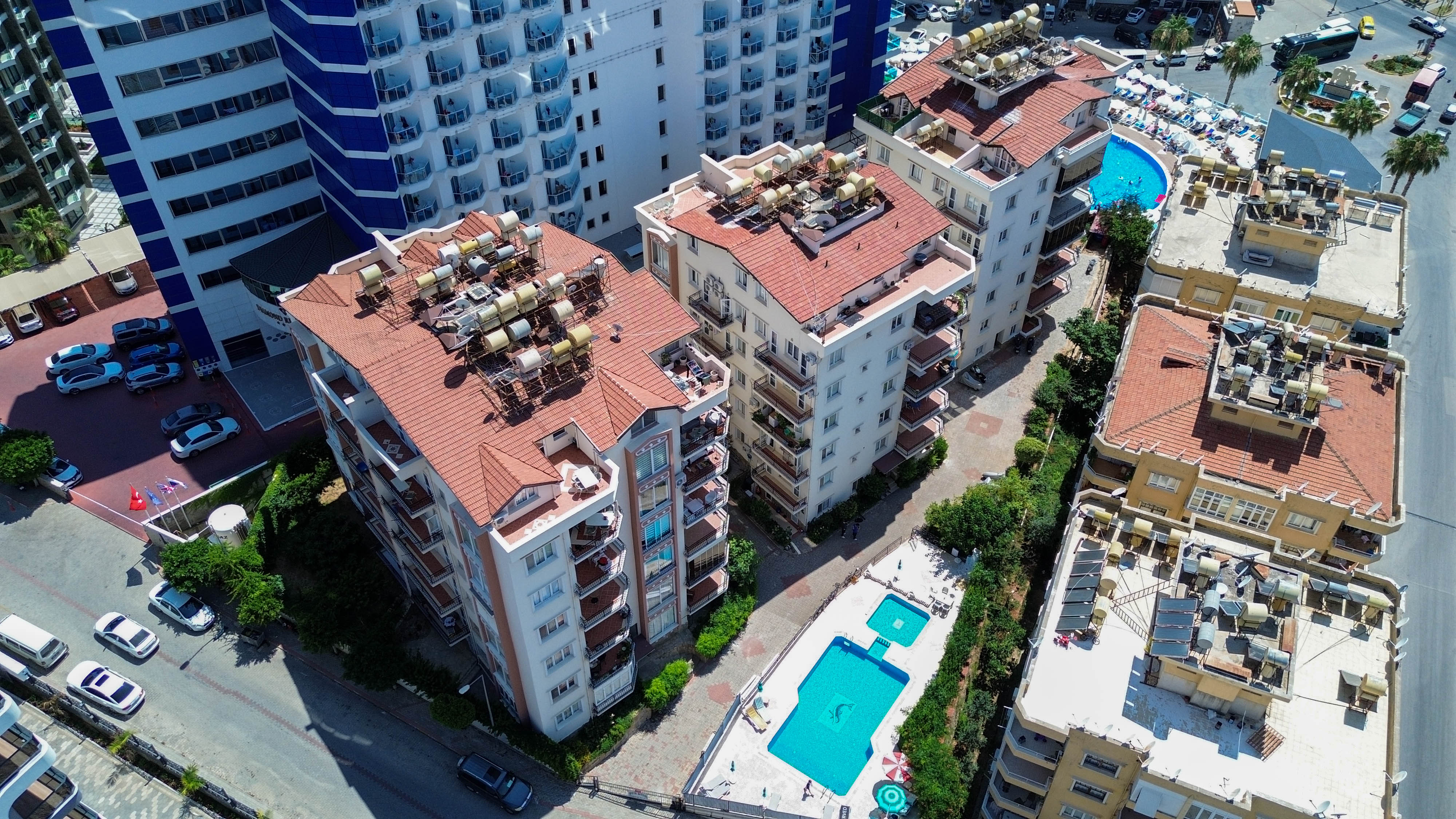 Avlu havuzu kırmızı kiremit çatılar ve çatı terasları Tosmur’daki yoğun şehir dokusunda görülüyor