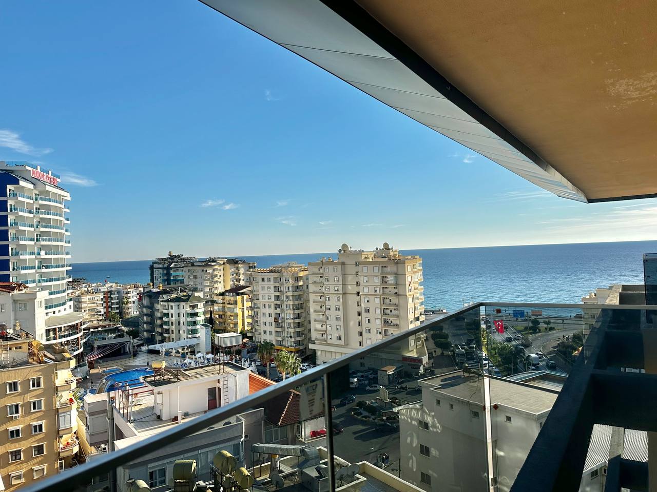 Cam korkuluklu teras, Türkiye’deki penthouse daireden denize ve şehir yapılarına bakıyor