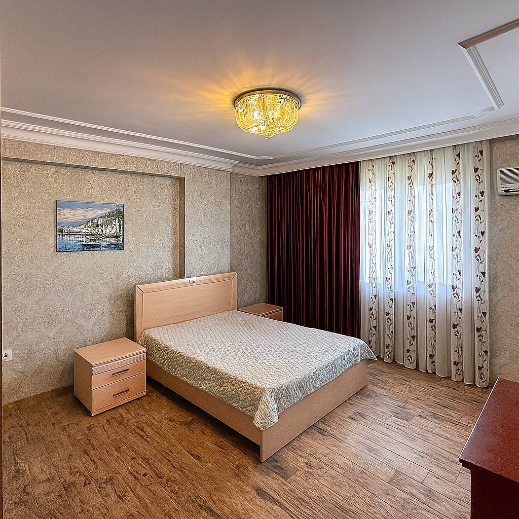 Bedroom with a double bed and wooden chest of drawers in a residence