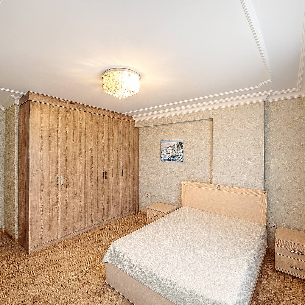 Bedroom with a double bed and tall wooden wardrobe in Tosmur