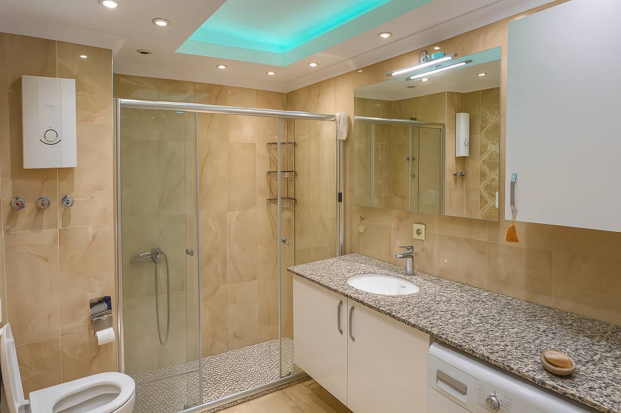 Bathroom with a glass shower and granite-effect vanity in Tosmur