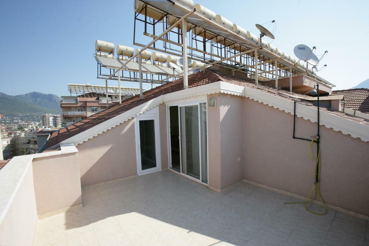 Rooftop terrace with tiled roofing and solar water heaters of a penthouse for sale in Turkey