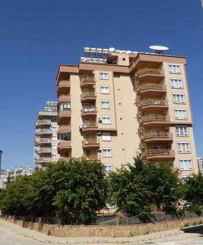 Multi-storey apartment building with balconies and solar water heaters in Tosmur