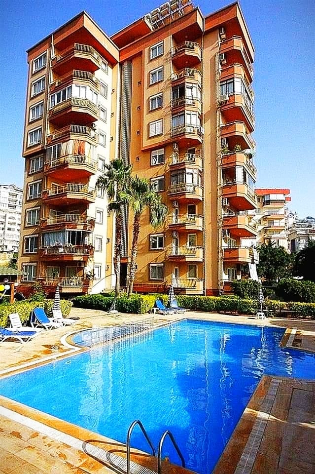 Large pool with a shallow area and loungers in a complex with penthouses for sale in Tosmur