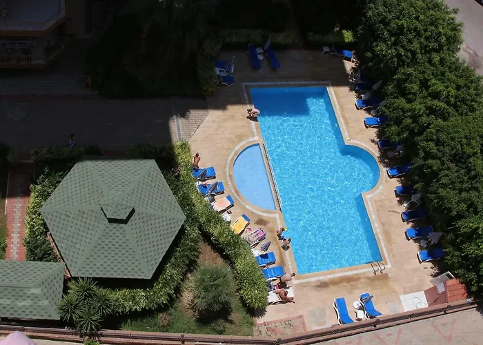 Top-down view of a shaped pool with a gazebo in a complex with residences