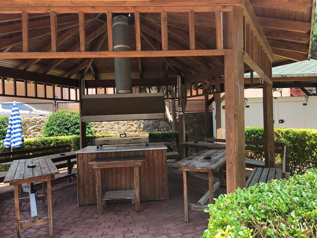 Wooden gazebo with a bar counter and tables on the grounds of a residence in Tosmur