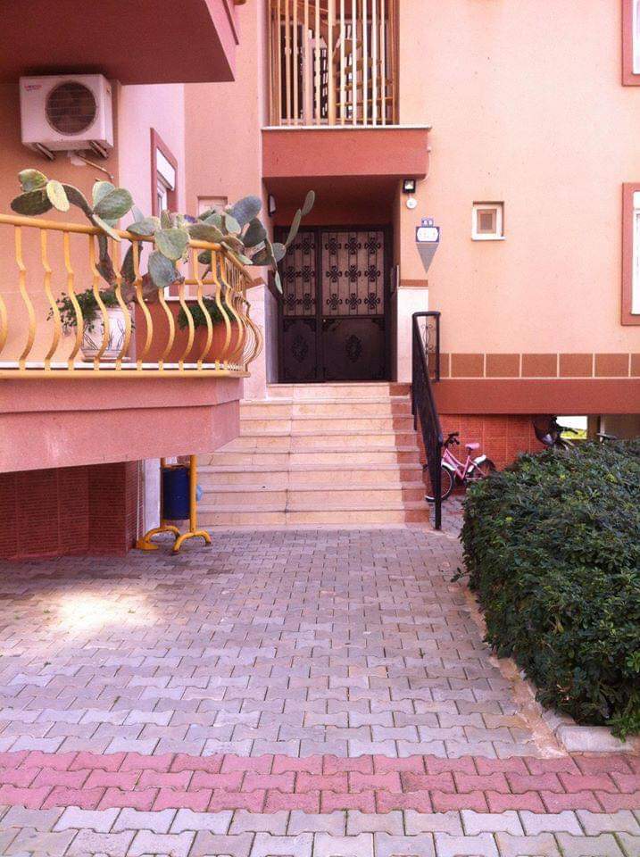 Entrance door with a decorative grille and steps in Tosmur